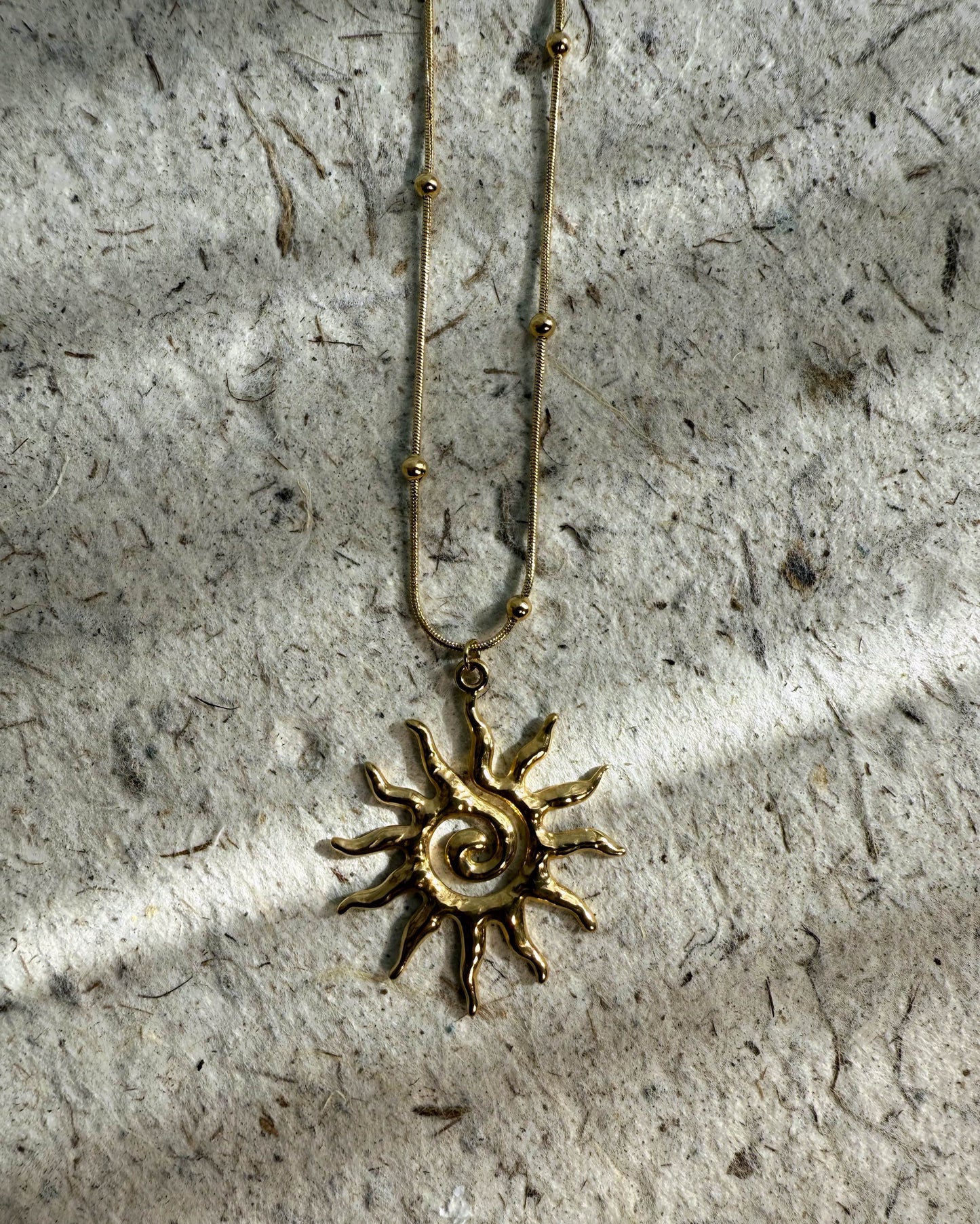 Sculptural gold jewelry inspired by sun spirals