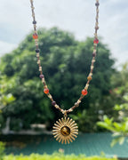 Gold sunburst necklace with earthy tones and natural stone center
