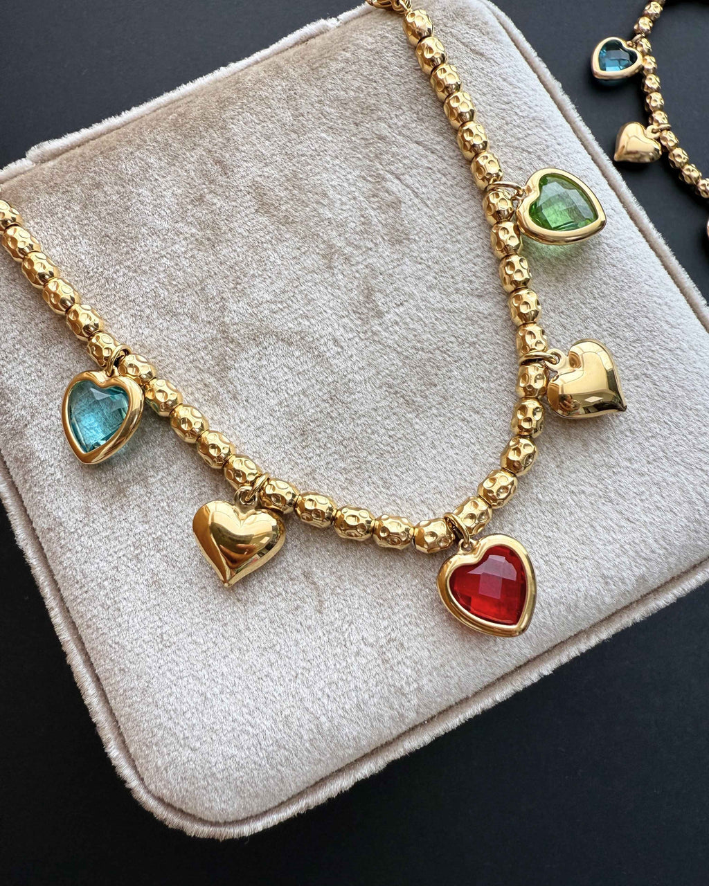ReflA gold beaded bracelet with heart charms and colorful zircon stones. Features a lobster clasp.