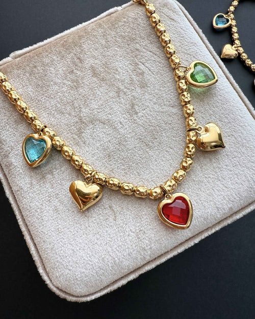 ReflA gold beaded bracelet with heart charms and colorful zircon stones. Features a lobster clasp.